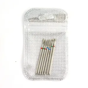 Close-up detail shot of 7pcs metal nail drill bits set with colorful rings inside silver bag.