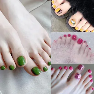 Dettaglio di unghie finte per piedi con vari colori solidi, glitter e simpatici motivi decorativi.