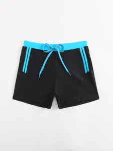 Men's black and blue contrast swim trunks detail view, featuring adjustable drawstring waist.
