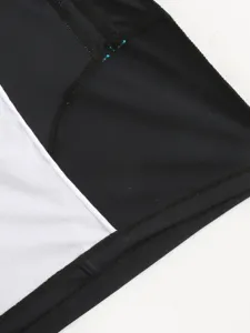 Men's swim trunks detail shot showing black fabric and white mesh splicing stitching.