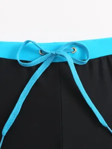 Men swim trunks drawstring waist detail close up, blue and black contrast design, stylish beach wear.