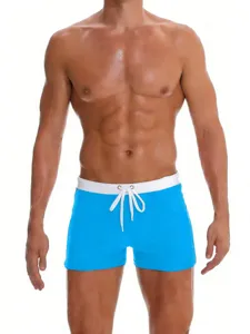 Men's solid blue swim trunks with white waistband and drawstring for comfortable beach sports.