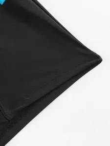 Men's swim trunks detail shot showing smooth stretch fabric, clean stitching and blue trim.