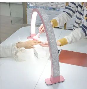 Detail view of crystal rhinestone half moon nail lamp providing bright lighting for salon use.