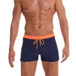 Men's solid color slim fit swim trunks with orange drawstring, front main product view.