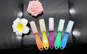 Detailed view of colorful mini nail cleaning brushes with stiff bristles for manicure art.