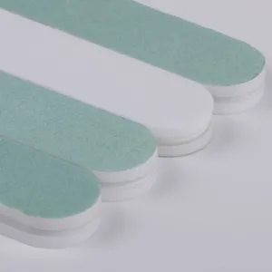Detailed close-up view of dual-sided green and white nail files showing abrasive textured surface.