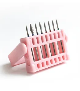 Close-up detail of nail drill bits in a pink plastic stand, clean and organized storage.