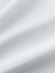 White waffle knit fabric texture close up, showing clear and soft material details.