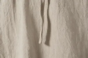 Close-up detail of men's casual linen shirt fabric texture and drawstring design features.