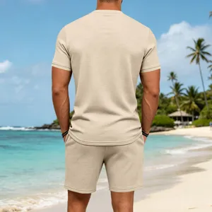 Detailed view of men's casual beige waffle knit short sleeve t-shirt and shorts set on beach.