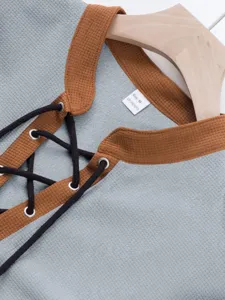 Waffle knit lace-up shirt detail view, featuring contrast stand collar and metal eyelets.