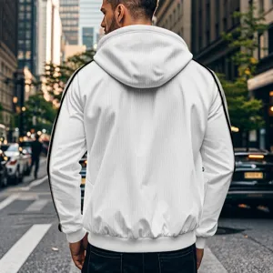 Detalle de chaqueta blanca casual con capucha y rayas negras en una escena urbana callejera.