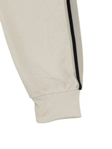 Detalle de puño de pantalón casual, tejido de gofrado con raya lateral, estilo urbano.