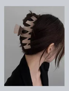 Detailed view of large matte hair claw clip, minimalist nude shark clip for stylish buns.