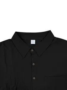 Detalle de camisa de manga corta de mezcla de lino negro clásico con botones y bolsillo.