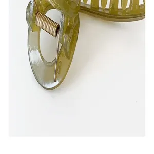 Close-up detail of the jelly green hair claw clip, featuring a sturdy metal spring structure.