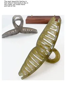 Detail view of large jelly color cross hair claw clip, clear resin texture, simple styling.