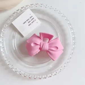 Pink matte bow hair claw clip for women, stylish and cute hair accessory for daily wear.