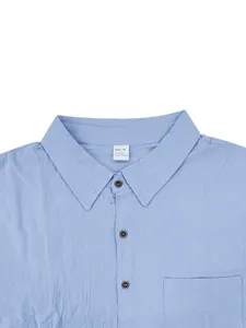 Detalle de cuello de camisa de lino azul claro, textura transpirable, bolsillo.