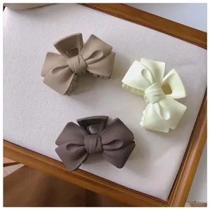 Matte bow hair claw clip detail showing the elegant design and secure grip for daily hairstyles.