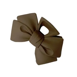 Matte coffee brown bow hair claw clip, elegant back head styling accessory for women.