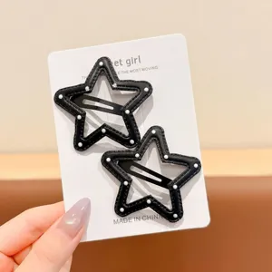 Detail shot of black and white polka dot star leather hair clips set on display card.