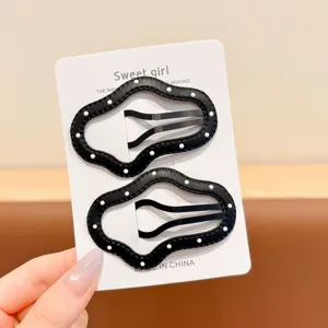 Close-up detail of black polka dot leather hair clips set, elegant chic side bang styling accessory.