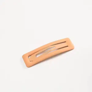 Dettaglio molletta per capelli opaca color pesca, design metallico elegante per donne.