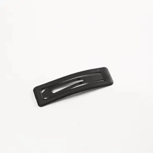 Primo piano di una molletta per capelli nera opaca con finitura in vernice gommata e design.