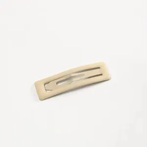 Primo piano dettagliato di una molletta per capelli opaca beige minimalista per frangia.