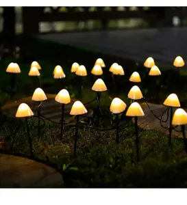 Glowing LED mushroom garden stake lights creating warm outdoor landscape illumination at night.
