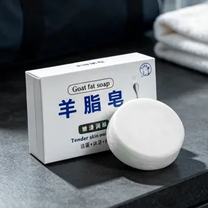 Goat fat soap detail view showcasing pure white round soap bar and matching packaging box.