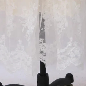 Weißes Spitzenkleid Hauptbild mit exquisitem Blumenstickerei Tiersaum und Details.