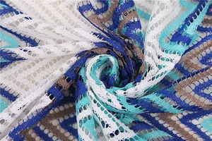 Detailed close-up of colorful wave lace fabric featuring hollow design, ideal for beach cover-ups.