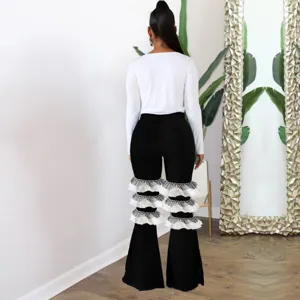 Vue détaillée de jean évasé à taille haute avec volants en tulle étagés et denim extensible.