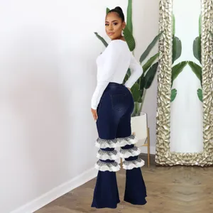 Vue détaillée du jean évasé à taille haute avec volants en tulle blanc à étages.