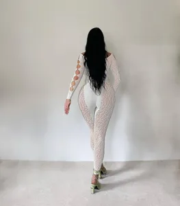 Back view detail showing sheer leopard print jumpsuit with stylish cutouts and pearl buttons.