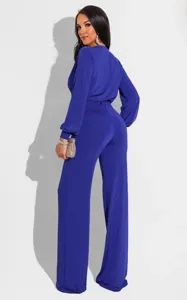 Detailed view of the elegant royal blue long-sleeve jumpsuit showcasing the tied waist.