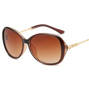 Occhiali da sole oversize vintage da donna con lenti sfumate e aste in metallo dorato.