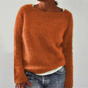 Detail view of orange long sleeve crew neck knit sweater showing texture and fit.