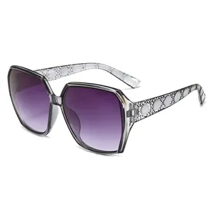 Chics lunettes de soleil grand cadre avec verres dégradés violet et motifs géométriques élégants.