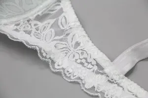Close-up detail of women's white floral lace bra strap and wing, elegant texture.