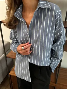 Detailed shot of casual blue and white striped long sleeve shirt with classic lapel collar.