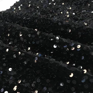 Close-up detail shot of black sequin fabric, showcasing sparkling texture and shining design.
