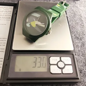 Vue détaillée d'une montre de sport tendance en silicone vert présentée sur balance.