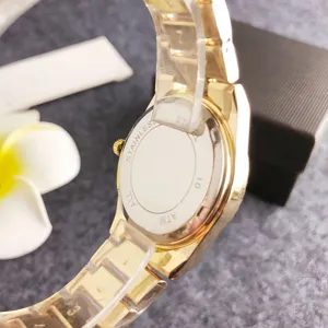 Gold quartz women watch back detail view, stainless steel case with protective film.