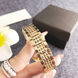 Detailed view of luxury gold women quartz watch strap with stylish studded pyramid design.