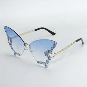 Exaggerated butterfly gradient blue rimless sunglasses with sparkling rhinestones and chic chain temples.