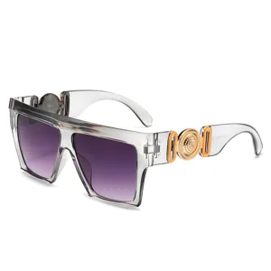 Luxe oversized vierkante zonnebril met paarse glazen en gouden tempelmedaillons.